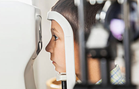 Photograph of a boy taking an eye exam.