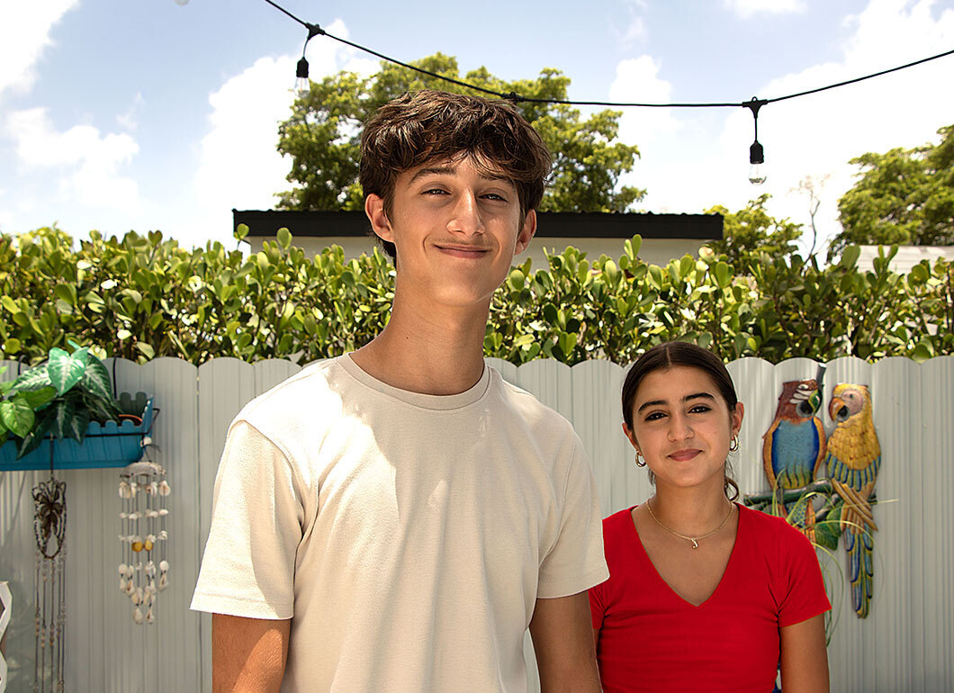 Photograph of a brother and sister smiling at the camera.
