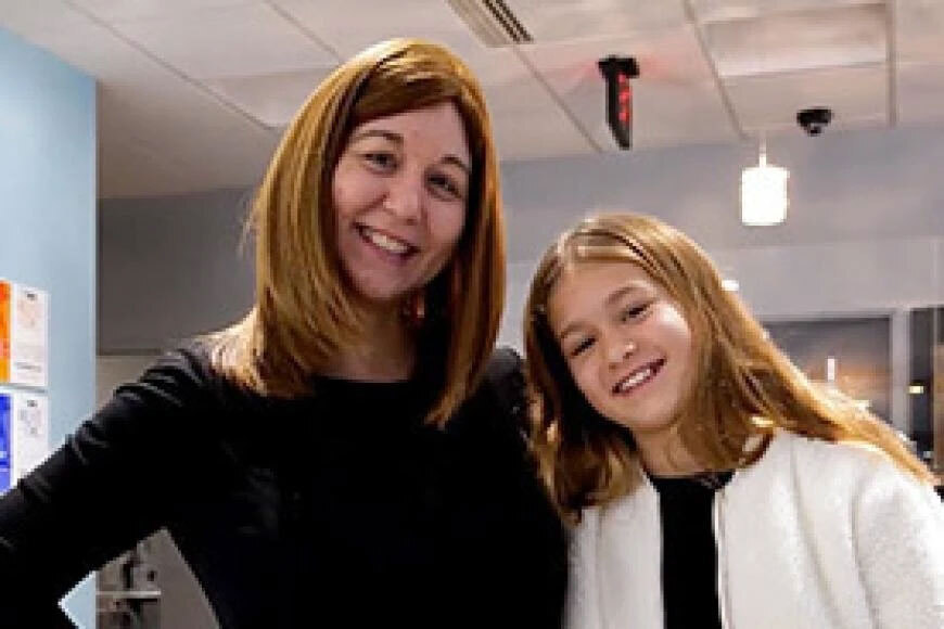 Photograph of a doctor and her daughter smiling.