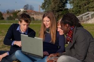 Students looking at a laptop outdoors.