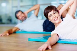 A man and woman exercising on yoga mats.
