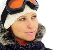 A woman smiling with winter goggles.