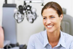 woman smiling at an eye care practitioner