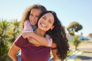 A happy mother and daughter outside.