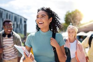 a happy female college student walking to class