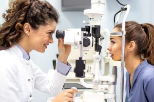 a close up shot of a young female optometrist with a patient in the exam room