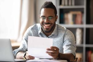 man happily reading letter.