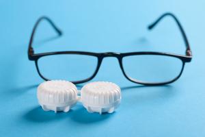 reading glasses next to contact lens case.