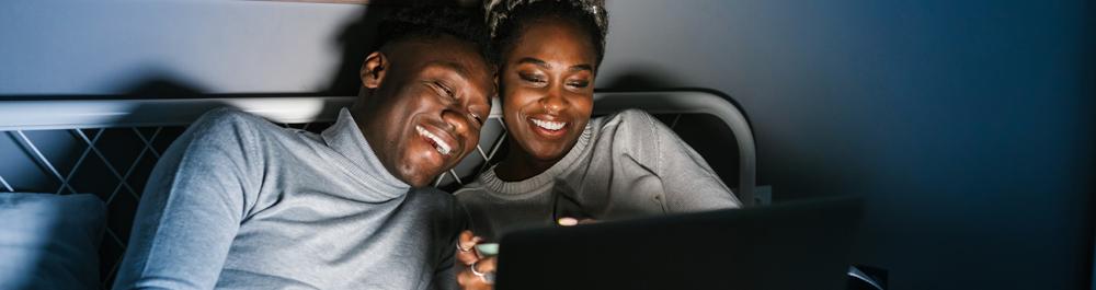 Couple smiling at a screen