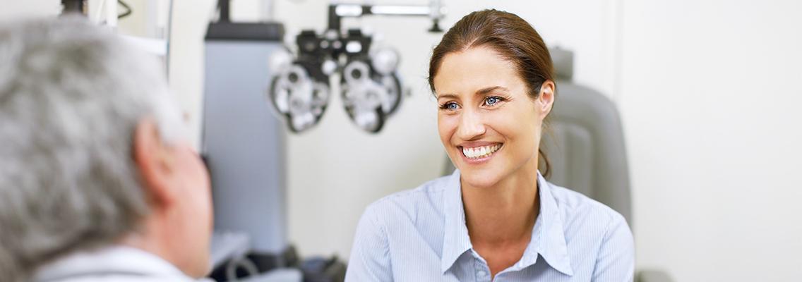 woman smiling at an eye care practitioner