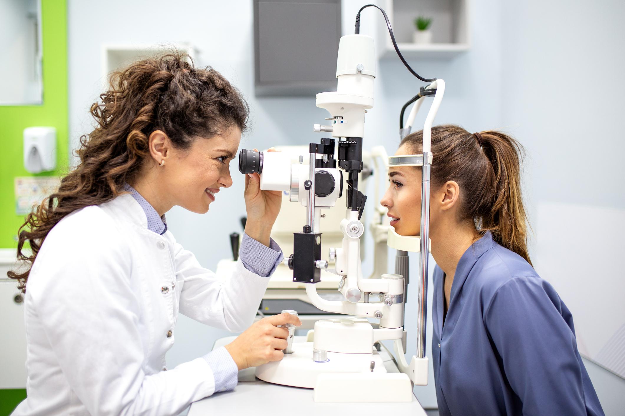a young female optometrist conducting an eye exam with a patient