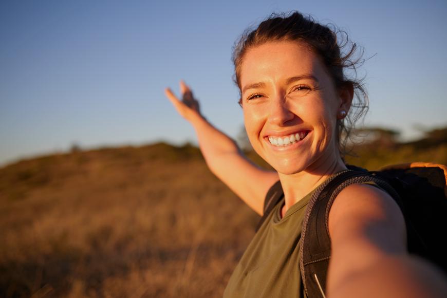 smiling young woman taking a selfie while hiking