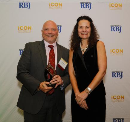 cropped photo of CooperVision's Jerry Warner receiving an award for the company's leadership and support of the Rochester, NY, community