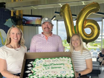 The owners of Elite Eye Care celebrate work anniversaries during monthly team meetings with employee recognition including a cake and balloons.
