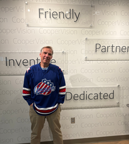 cropped photo of CooperVision's Steve Robins wearing Rochester hockey jersey
