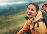 smiling young woman outside while hiking