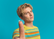 young man holding a contact lens on his index finger