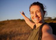 smiling young woman taking a selfie while hiking