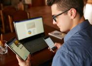 A young professional using numerous digital devices at once.