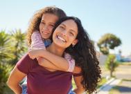 A happy mother and daughter outside.