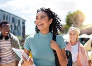 a happy female college student walking to class