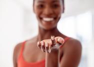 young woman holding a contact lens