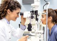 a close up shot of a young female optometrist with a patient in the exam room