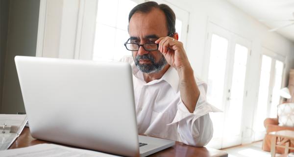 man with glasses looking at computer screen